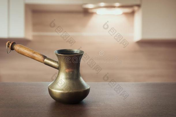 酿酒的铜土耳其式咖啡壶向木制的桌面和现代的厨房同样地波黑