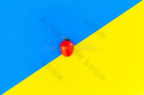 新鲜的小的番茄向蓝色和黄色的背景.顶看法科普斯