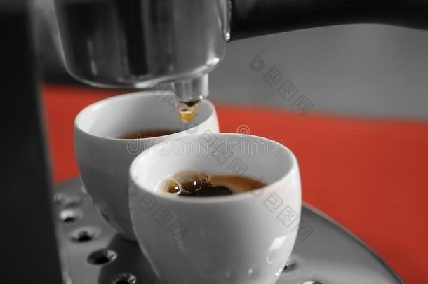 新的<strong>咖啡</strong>豆制造者传布新鲜的浓<strong>咖啡</strong>进入中两个杯子,