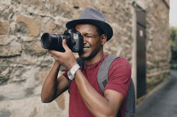 非洲的幸福的旅行者迷人的照片向他的单眼数位相机照相机.年幼的男人