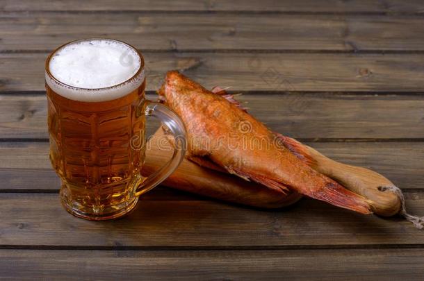 新鲜的啤酒采用马克杯和起泡沫和熏制的鱼