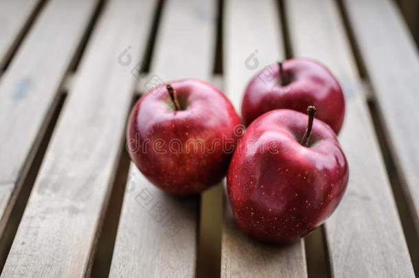 num.三黑暗的红色的<strong>苹果</strong>向木制的表面顶看法