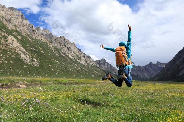 远足野营女人用于跳跃的向花和草