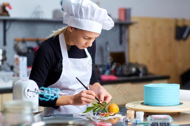 一糖果制造人女人装饰一c一ke向一t一ble采用指已提到的人厨房.