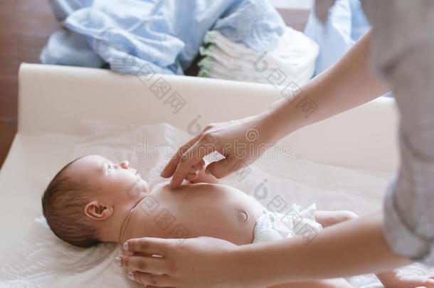 母亲变化有菱形花格的麻或棉织物向她新生的婴儿