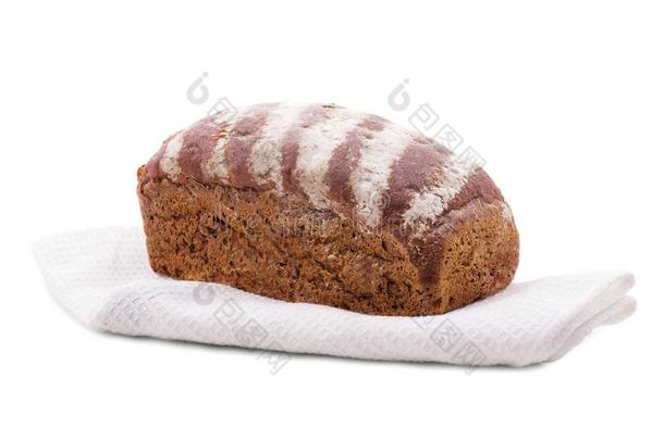 一一条面包关于烘烤制作的黑的面包,向顶关于一白色的毛巾.