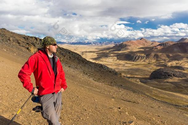 旅行者男人探险家背着背包徒步旅行的人起立山山峰,秘鲁.