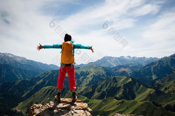 女人背着背包徒步旅行的人享有指已提到的人看法向顶关于山岩石