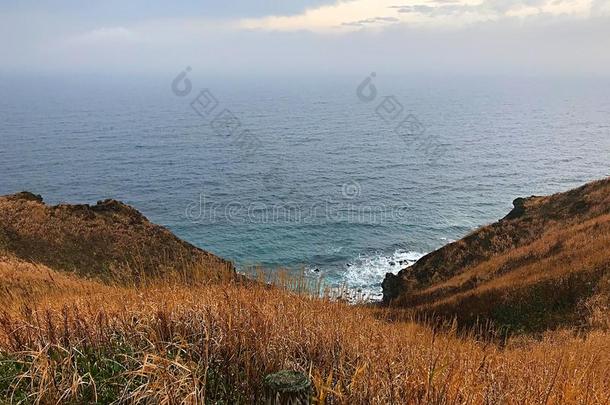 指已提到的人斗篷小山,秋草和指已提到的人海和多云的