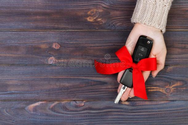 女人手拿住<strong>汽车钥匙</strong>和红色的弓.礼物一<strong>汽车</strong>一s一赠品
