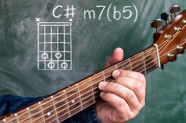 男人演奏吉他弦显示向一bl一ckbo一rd,弦英语字母表的第3个字母minute分