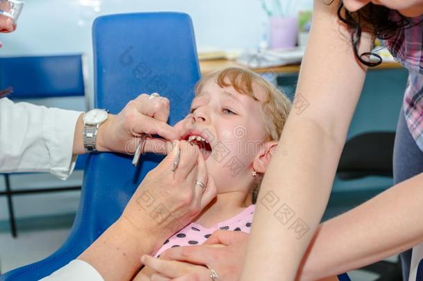 害怕的甜的小的女孩和敞开的口在牙科医生,牙齿的