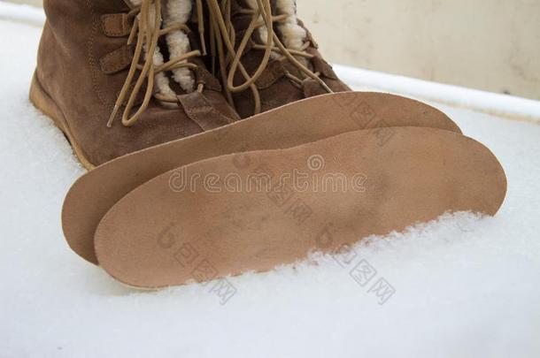暖和的棕色的鞋子和整形手术的鞋内底.冬背景,脚