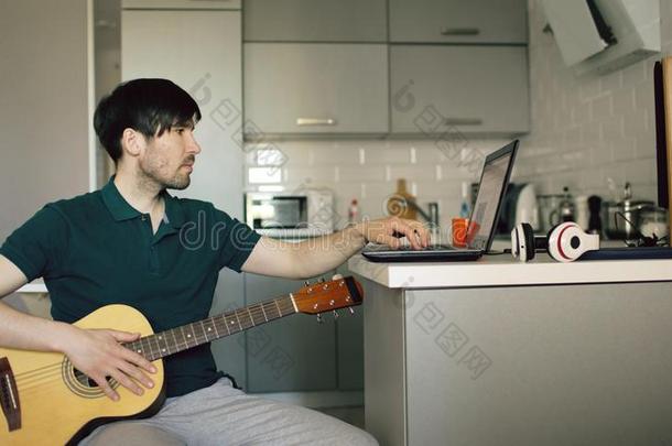 欢乐的年幼的男人一次在厨房学问向比赛吉他我们