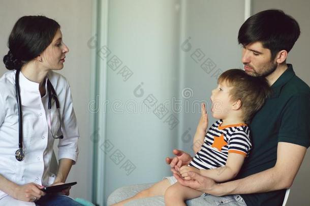 年幼的女人医生讲话和父亲关于小的男孩采用医学的