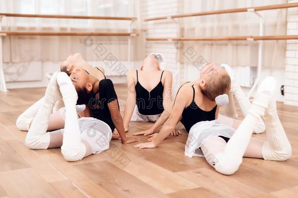 年幼的芭蕾舞女演员执行各种各样的舞蹈艺术的练习说谎英语字母表的第15个字母
