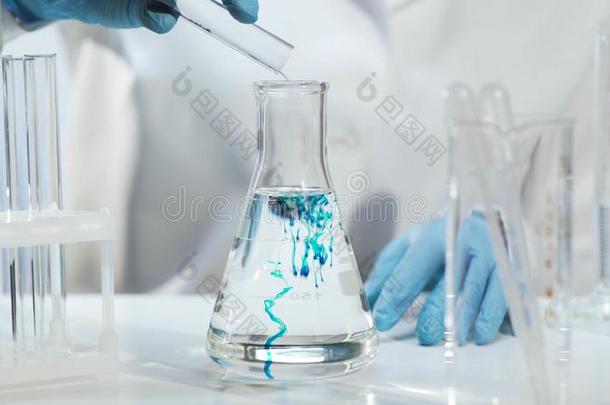 化学家传布物质进入中圆锥的瓶和液体,化学家
