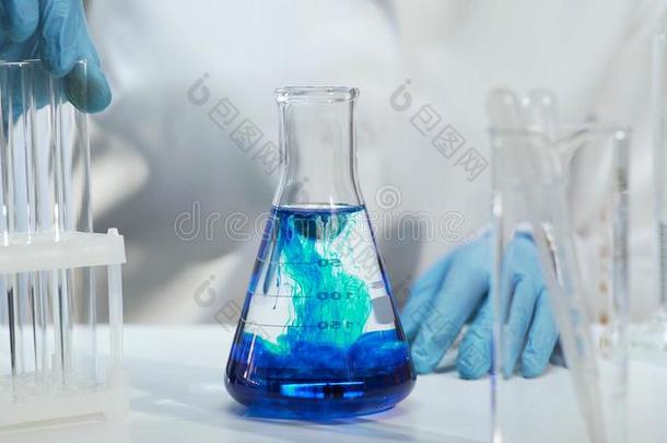 关-在上面关于圆锥的瓶和蓝色液体,化学的实验