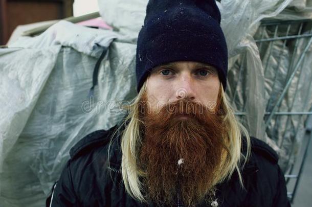 特写镜头肖像关于年幼的有胡须的无家可归的男人一次向一面