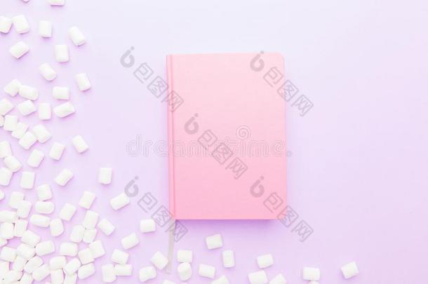 棉花糖框架和粉红色的笔记簿向粉红色的背景
