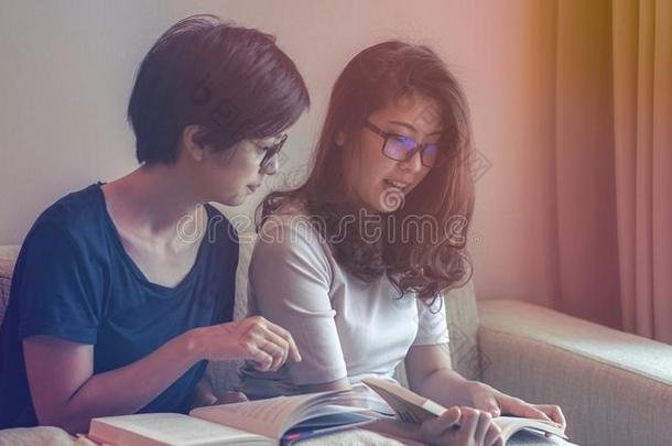 两个亚洲人女人朋友阅读书和讨论向业余爱好