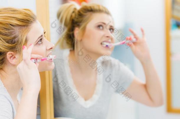 女人疾驰的清洁牙采用浴室