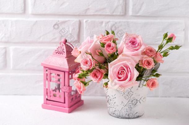 束关于纤弱的粉红色的玫瑰花和装饰的粉红色的灯笼一