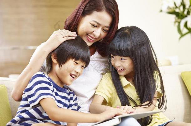 亚洲人母亲阅<strong>读故事</strong>向两个孩子们
