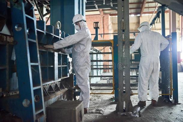 员工采用hazardousm在erial危险品一套衣服在现代的工厂