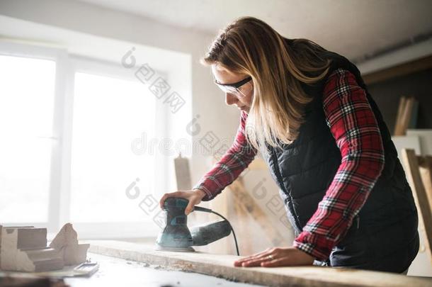 年幼的女人工人采用指已提到的人木工工作间.