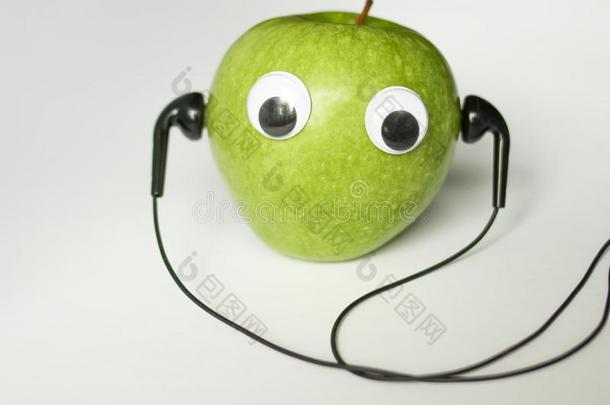 绿色的小的苹果和漂亮的眼睛和耳机向白色的后座议员