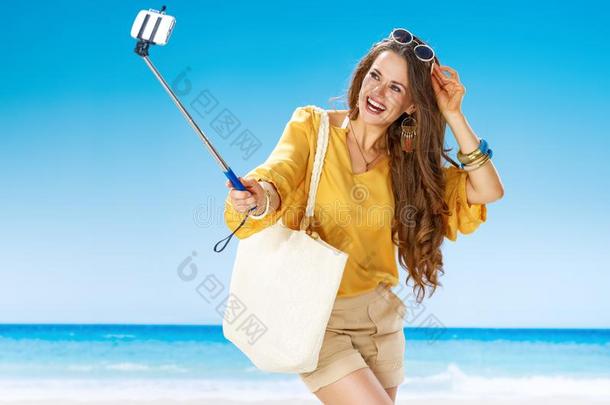 幸福的女人向海岸迷人的自拍照使用自拍照粘贴