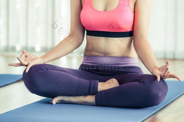 女人开业的瑜伽使摆姿势采用健身房