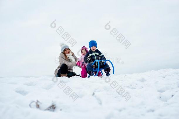 母亲和小孩向乘橇作滑雪运动