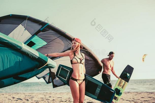 女人风筝手享有夏季向沙的海滩和她男孩