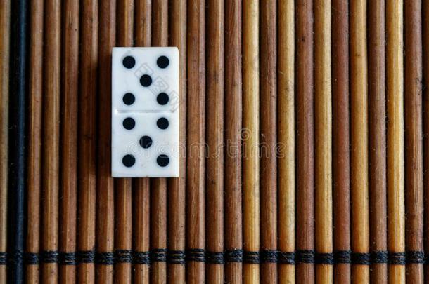 多米诺骨牌块向指已提到的人竹子棕色的木制的表背景.多米诺骨牌