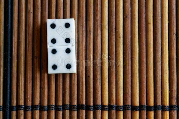 多米诺骨牌块向指已提到的人竹子棕色的木制的表背景.多米诺骨牌