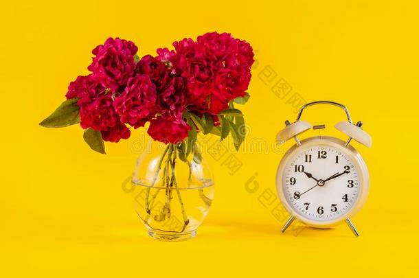 老的钟和红色的玫瑰花采用装饰瓶向黄色的背景