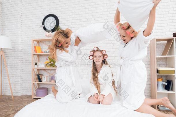 两个成熟的女人和一女孩pl一y一战斗和枕头向指已提到的人床.