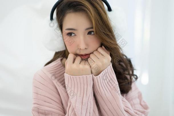 美丽的亚洲人女孩寒冷的使人疲乏的白色的护耳和暖和的出汗