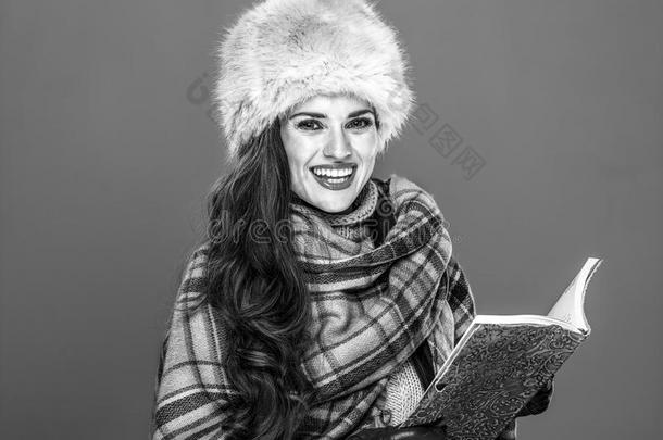 微笑的时髦的女人向寒冷的蓝色背景和书