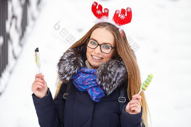 年幼的美丽的微笑的年幼的女人采用圣诞节鹿头盔