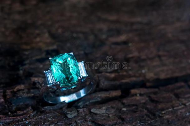 特写镜头绿色的<strong>宝石戒指</strong>和白色的钻石向老的木制的后台