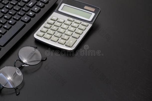 办公室黑的书桌表和计算机,计算器,智能手机,英语字母表的第7个字母