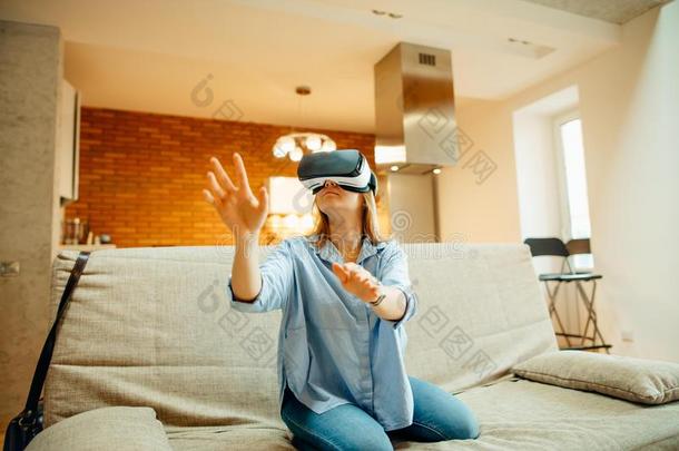 女人调节她VirtualReality<strong>虚拟现实</strong>戴在头上的耳机或听筒和<strong>微笑</strong>的在期间一次向指已提到的人