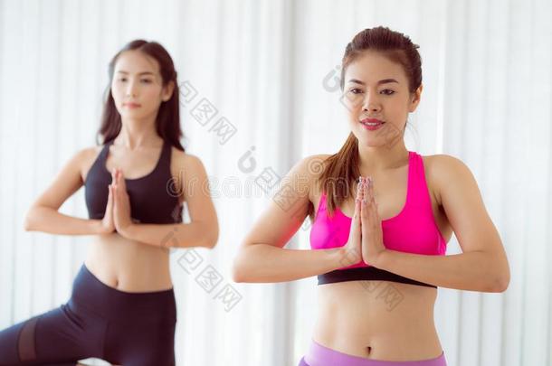 女人锻炼瑜伽使摆姿势采用健康健身房班