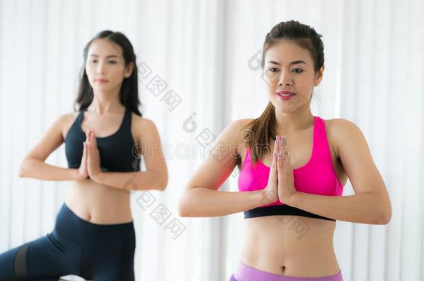 女人锻炼瑜伽使摆姿势采用健康健身房班