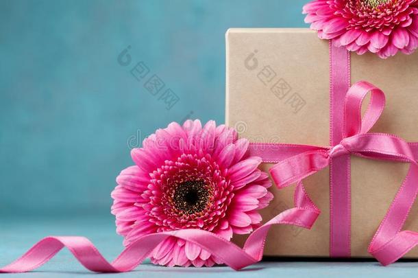 赠品盒和弓带和粉红色的花向绿松石表.Greece希腊