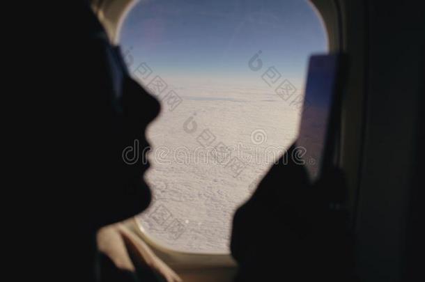 特写镜头轮廓女人一次在近处飞机窗使用莫比