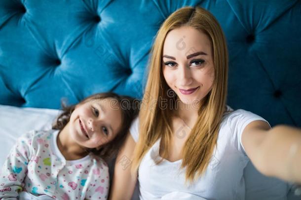 幸福的母亲和女儿采用睡衣tak采用g自拍照和斯马特福